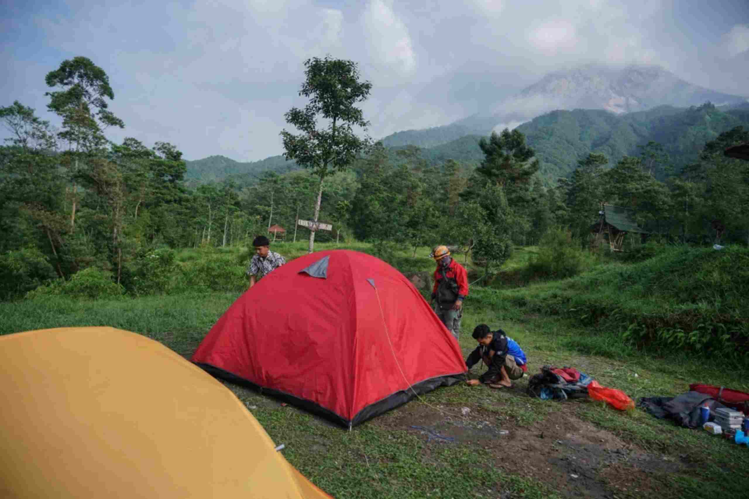Personel Tim Reaksi Cepat (TRC) BPBD DIY (dua kiri) dibantu warga mengemas tenda milik wisatawan di Bukit Klangon